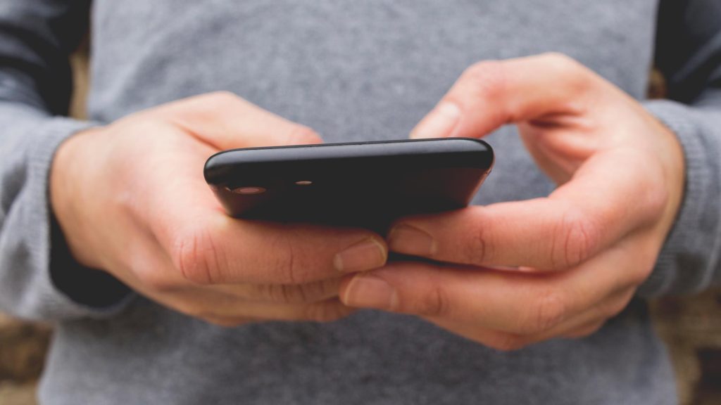 A young male checking his smart phone