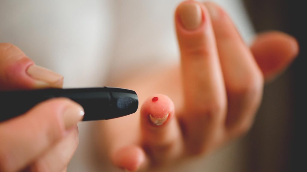 Female administering a diabetic glucose self-check