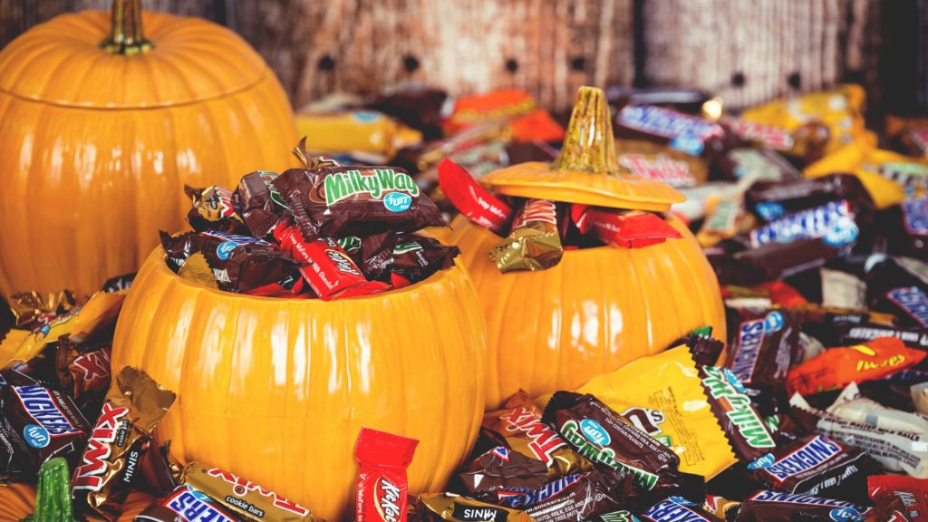 Photo of jack-o-lantern candy buckets overflowing with candy bars