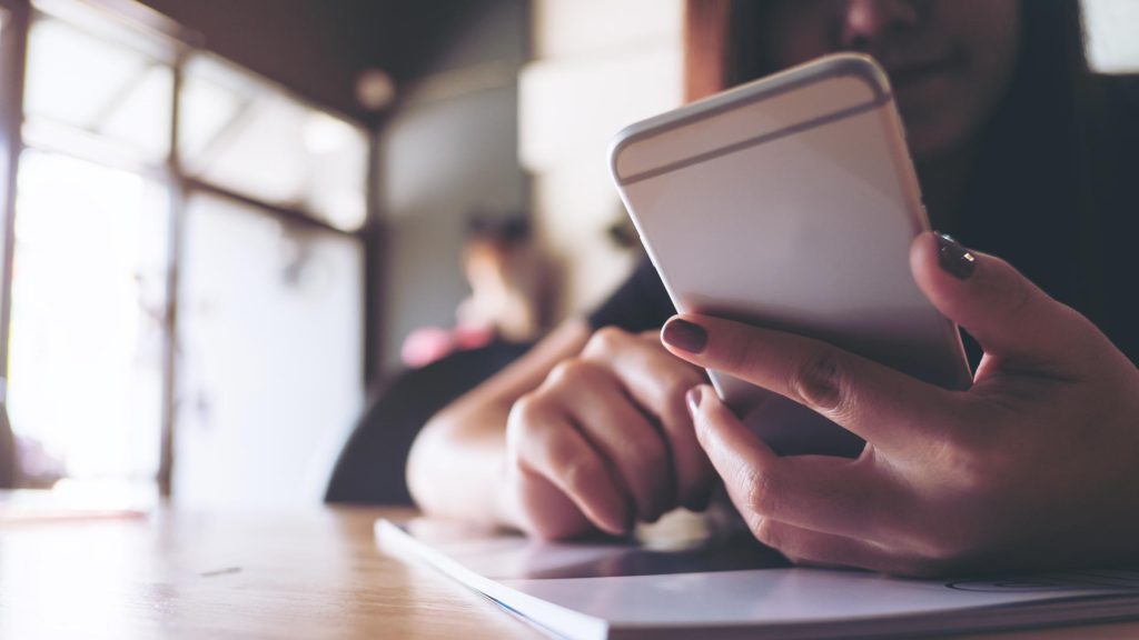 Young woman interacting with smart mobile phone