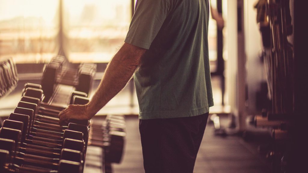 Older male looking at a set of free weights