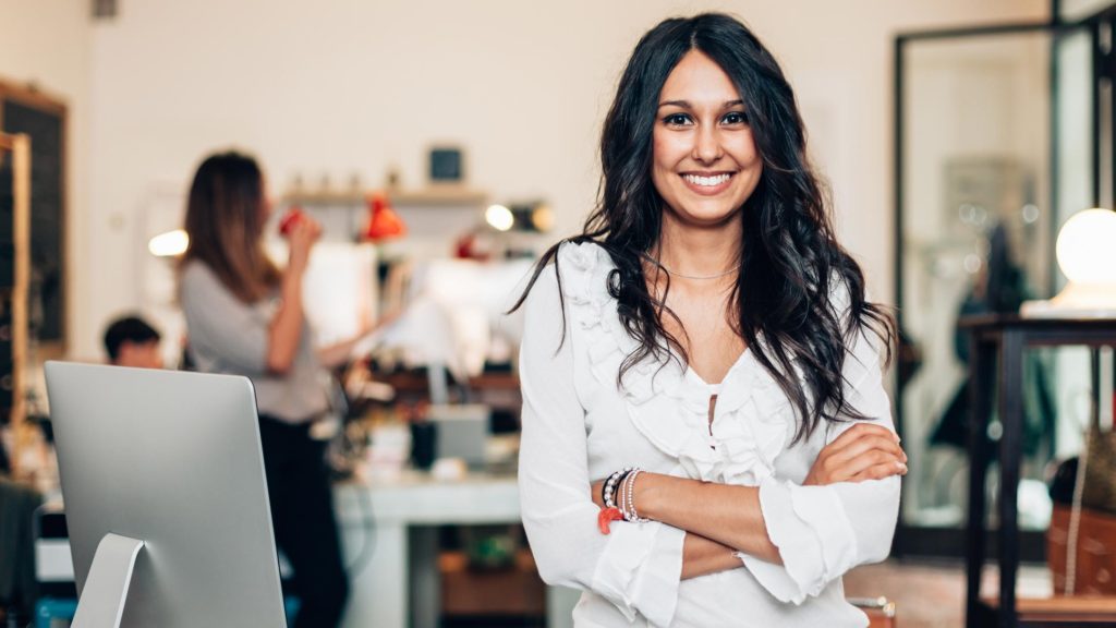 A confident young female smiling in an office setting